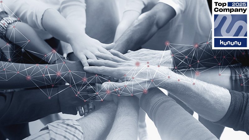 viele Hände unterschiedlicher Menschen treffen in der Mitte aufeinander und symbolisieren Teamgeist