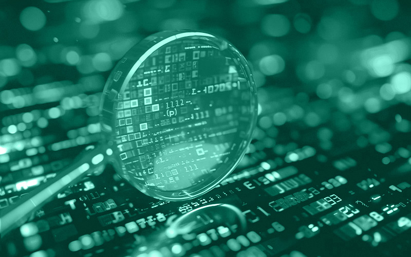 eine Lupe untersucht eine Elektronik-Platine im Detail