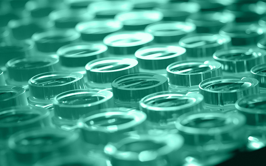 eine Mikrotiterplatte mit gefüllten Einzelwells, von denen eins rot eingefärbt ist