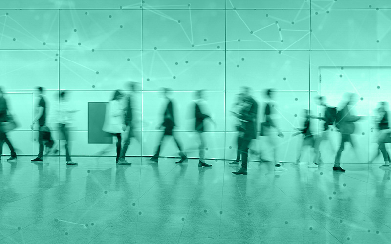 Eine Gruppe von Menschen geht durch die Eingangshalle einer Messe