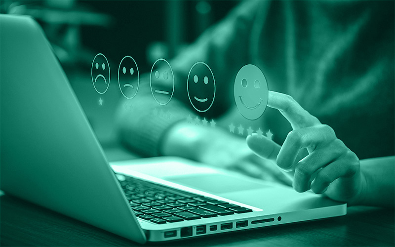 Eine Person sitzt vor dem aufgeklappten Laptop